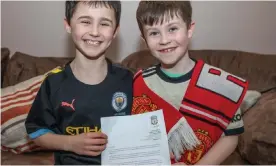  ?? Photograph: North West Newspix ?? Manchester United fan, Daragh Curley, left, and his brother Dylan, a Manchester City fan, with his letter from Jürgen Klopp.