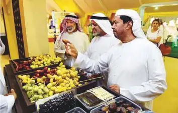  ?? Abdul Rahman/Gulf News ?? Visitors examine dates grown on Zirku Island, 140km northwest of Abu Dhabi city, yesterday.