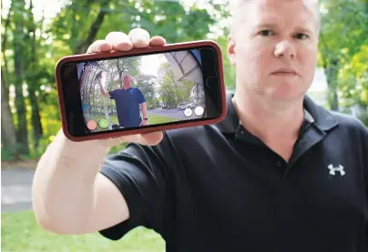 ?? AP PHOTOS/JESSICA HILL ?? Ernie Field holds up a live video of himself taken by a Ring doorbell camera at the front door at his home in Wolcott, Conn. Field won a free Ring camera and said he had to register for the app to qualify for the raffle. Now he gets alerts on his phone when a car drives by and a 30-second video when his daughter gets home from school.