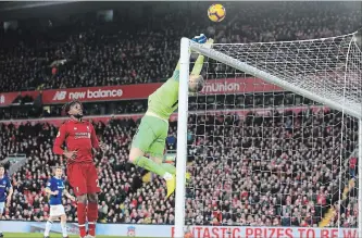  ?? JON SUPER THE ASSOCIATED PRESS ?? Everton goalkeeper Jordan Pickford saves a ball in front of Liverpool forward Divock Origi before Origi scores.
