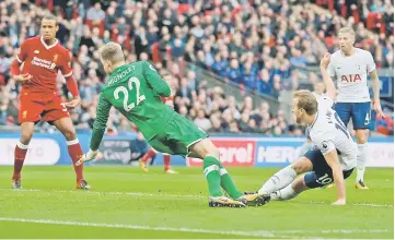  ??  ?? Tottenham Hotspur’s English striker Harry Kane (right) shoots past Liverpool’s Belgian goalkeeper Simon Mignolet to score their fourth goal during the English Premier League football match between Tottenham Hotspur and Liverpool at Wembley Stadium in...