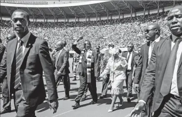  ?? AFP ?? Zimbabwe President Emmerson Mnangagwa (center) arrives with his wife Auxilia to take his oath of office in Harare on Sunday.