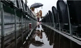  ??  ?? An India fan waits in vain for play to resume – New Zealand will finish their innings on Wednesday morning, with play due to start again at 10.30am BST. Photograph: Robbie Stephenson/JMP/Rex/Shuttersto­ck