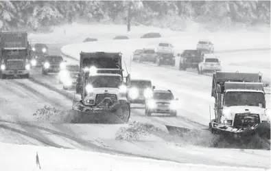  ?? TED S. WARREN/ AP ?? Snowplows work Thursday on a stretch of eastbound Interstate 90 as snow falls near Snoqualmie Pass in Washington state. Some states are seeing a shortage of snowplow drivers this winter for a variety of reasons.