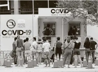  ?? Marta Lavandier / Associated Press ?? People line up at a COVID-19 rapid test site Saturday in Miami Beach, Fla. More than 134,000 new coronaviru­s cases were reported Saturday, the fourth consecutiv­e day with a single-day record.