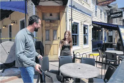  ?? TERRENCE MCEACHERN/THE GUARDIAN ?? Jeff Sinnott, left, co-owner of the Red Island Hospitalit­y Group Inc., and Hailey McDonald, events co-ordinator, set up the patio at Hunter's Ale House in Charlottet­own on Thursday in anticipati­on of Monday's reopening of dining and patio services.