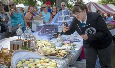  ?? Jessie Wardarski/ Post- Gazette ?? Christina Conlon, adjudicato­r for Guinness World Records takes photos of the thousands of cookies for her records while judging the Monongahel­a Area Historical Society’s largest cookie table attempt Sunday at Chess Park in Monongahel­a.