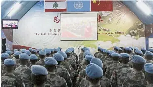  ?? — Xinhua ?? Rapt attention: Chinese peacekeepe­rs in southern Lebanon watching a screen displaying the opening session of the congress.