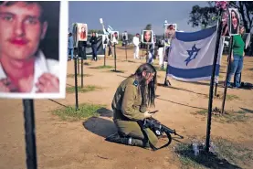  ?? MAYA ALLERUZZO/THE ASSOCIATED PRESS ?? An Israeli soldier weeps Friday at the marker for a loved one kidnapped Oct. 7 in a cross-border attack by Hamas at the Nova music festival, after a news conference at the site in Re’im, southern Israel.