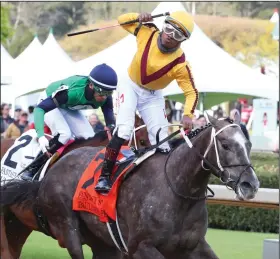  ?? (The Sentinel-Record/Richard Rasmussen) ?? Jockey Ricardo Santana Jr. (right) celebrates as he crosses the finish line to win the Fantasy Stakes by 1 length aboard Pauline’s Pearl on Saturday at Oaklawn Racing Casino Resort in Hot Springs. Ava’s Grace, ridden by Ramon Vazquez, was second.