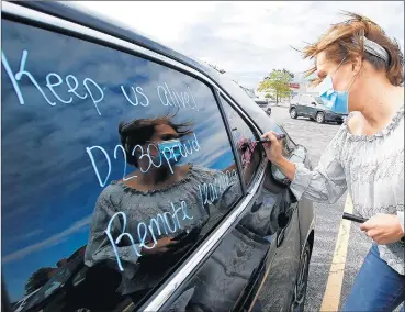  ?? JOHN SMIERCIAK/DAILY SOUTHTOWN PHOTOS ?? Emma Schmidt, a teacher at Stagg High School, decorates her car as about 50 educators from High School District 230 took their concerns about the start of the new school year to the public Tuesday.