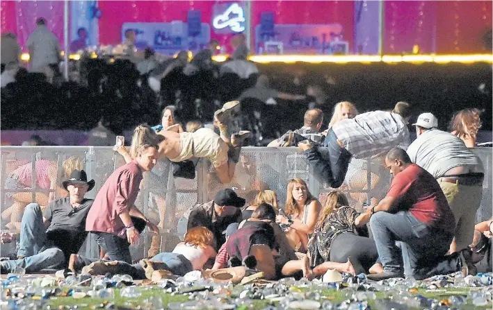  ?? AFP ?? Desbandada. Un grupo de jóvenes intenta cubrirse de los disparos de Paddock, en plena avenida de Las Vegas y en medio del recital. El presidente Trump, conmovido por el hecho.