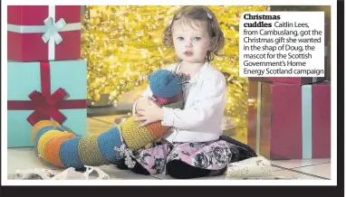  ??  ?? Christmas cuddles Caitlin Lees, from Cambuslang, got the Christmas gift she wanted in the shap of Doug, the mascot for the Scottish Government’s Home Energy Scotland campaign