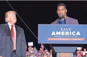  ?? BEN GRAY/AP ?? Former President Donald Trump listens as Georgia Senate candidate Herschel Walker speaks during his Save America rally in Perry, Ga., on Saturday.