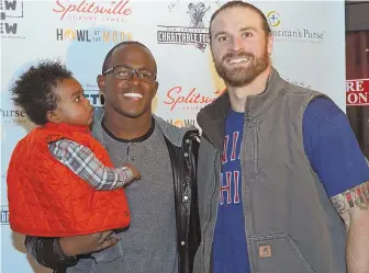  ?? STAFF PHOTO BY STUART CAHILL ?? FEELING CHARITABLE: Matthew Slater holds his son Jeremiah and poses with Patriots teammate Chris Long during Slater’s fund raiser to benefit Samaritan’s Purse last night at Patriot Place.