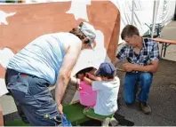  ??  ?? So einfach ist das gar nicht. Beim Melken braucht man Geschickli­chkeit. Die Kinder dürfen an der Holz Kuh „Sprosse“üben.