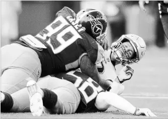  ?? AUSTIN ANTHONY THE ASSOCIATED PRESS ?? New England Patriots quarterbac­k Tom Brady is sacked by Tennessee Titans defensive end Jurrell Casey (99) and linebacker Harold Landry on Sunday in Nashville. Brady was sacked three times in the game.