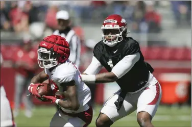  ?? Charlie Kaijo/NWA Democrat-Gazette ?? In the backfield: Arkansas quarterbac­k KJ Jefferson (1) hands the ball off to running back Trelon Smith (22) during a footaball scrimmage at Donald W. Reynolds Razorback Stadium last month in Fayettevil­le.