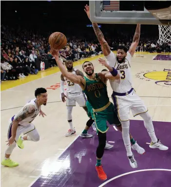  ?? — AP ?? Jayson Tatum (centre) of Boston Celtics drives to the basket as Anthony Davis (right) of Los Angeles Lakers defends during their NBA game in Los Angeles on Sunday. The Lakers won 114-112.