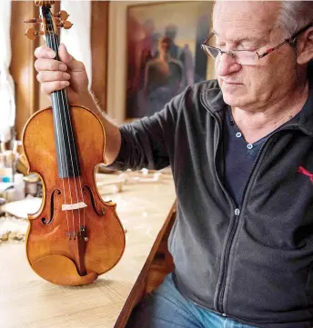  ?? — AFP photo ?? Bogdanoski works on his last violin in his workshop in Veles.