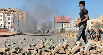  ?? | AFP ?? PROTESTERS use bricks to block a street in the Sudanese capital Khartoum this week, during a demonstrat­ion against the killings of civilians in a crackdown since last year’s military coup.