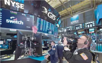  ?? — AFP ?? A cameraman works on the floor at the closing bell of the Dow Industrial Average at the New York Stock Exchange.