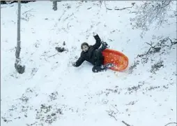  ?? ?? HAILEY LONG, 8, takes a tumble while sledding Monday on a hillside by her home in Frazier Park, Calif., after a storm brought snow to Kern County.