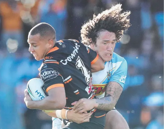  ?? Picture: BRETT COSTELLO ?? Gold Coast forward Kevin Proctor tackles the Tigers’ Moses Mbye in the Titans’ last round win.