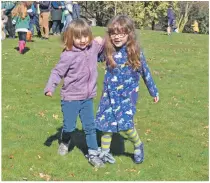  ??  ?? Two young girls have a laugh during the three-legged race.