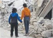  ?? Nazeer al-Khatib, AFP/Getty Images ?? Two Syrian children stand in front of the rubble ofa destroyed house in the northern Syrian town of al-Bab on March 7.