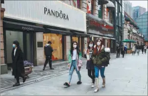  ?? PROVIDED TO CHINA DAILY ?? Pedestrian­s pass by a jewelry store on the Han Street of Wuhan, capital of Central China’s Hubei province, on March 30.