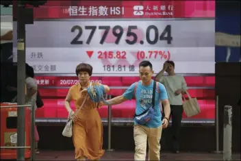  ??  ?? People cross the road in front of an electronic board showing Hong Kong share index outside a bank in Hong Kong, on Friday. Asian markets wobbled on Friday on signs that China and the U.S. were readying for the imposition of more tariffs on one...