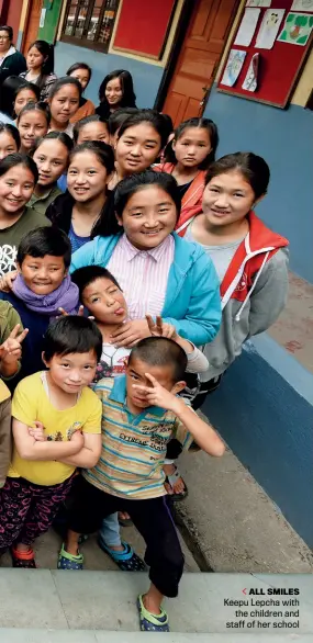  ??  ?? ALL SMILES
Keepu Lepcha with the children and staff of her school