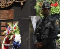  ?? MARIAN DENNIS – DIGITAL FIRST MEDIA ?? State troopers and local police stood around the Fraternal Order of Police memorial that sits at the front of the Montgomery County Courthouse in Norristown. A ceremony was held Friday to honor the fallen officers who died or were killed in the line of...