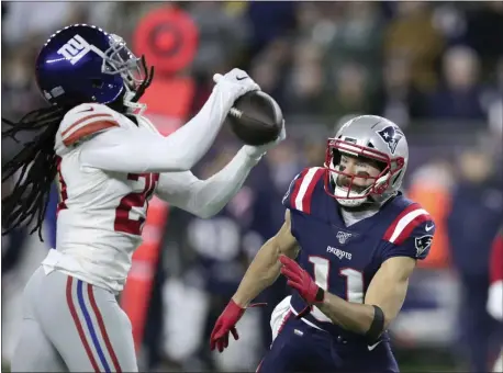  ?? CHARLES KRUPA — AP PHOTO ?? Giants cornerback Janoris Jenkins, left, intercepts a pass intended for Patriots wide receiver Julian Edelman, right, during last Thursday’s game in Foxborough, Mass.