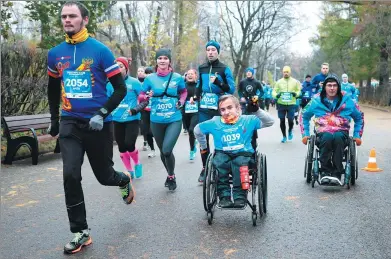  ?? SERGEI BOBYLEV / TASS NEWS AGENCY ?? People take part in the 2017 Paralympic Season run in Moscow’s Sokolniki Park on Sunday.