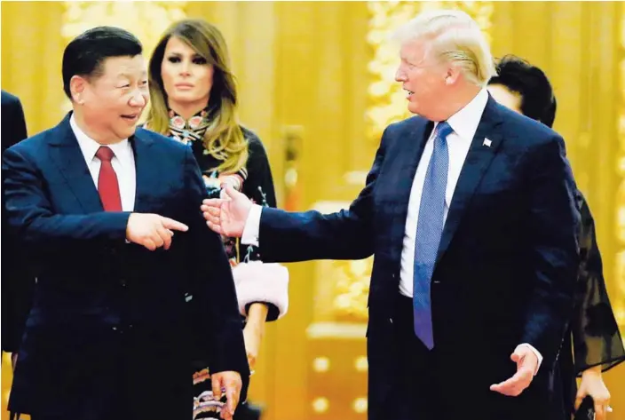  ?? AP ?? El presidente de Estados Unidos, Donald Trump, y el mandatario de China, Xi Jinping (izq.), conversaro­n ayer al llegar a la cena en el Gran Salón del Pueblo en Pekín.