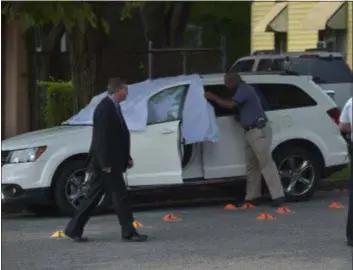  ?? PETE BANNAN — DIGITAL FIRST MEDIA ?? Police cover a car where a man was fatally shot on the 900 block of Yarnall street in Chester Monday morning.