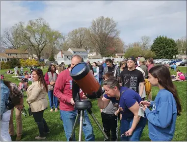  ?? BILL RETTEW — MEDIANEWS GROUP ?? Delaware County resident and West Chester University student Andrea Lojano takes a look into the sun during Monday’s eclipse.