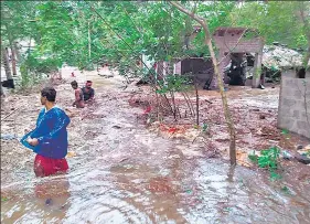  ?? ANI/PTI ?? (Left) NDRF personnel carry out a rescue operation during cyclone ‘Yaas’, in Kalighat, Kolkata, on Wednesday; (above) People wade through waterlogge­d street at Gheri village after heavy rain due to the landfall of the cyclone in Odisha’s Balasore district.