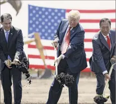  ?? Evan Vucci / Associated Press ?? President Donald Trump, center, then-wisconsin Gov. Scott Walker, left, and then-foxconn Chairman Terry Gou, wield shovels at a groundbrea­king for a planned Foxconn facility in Mount Pleasant, Wis. The promise of a $10 billion complex employing 13,000 people has shrunk to a single site employing 520 where Google servers will be assembled.