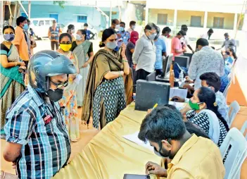  ?? — DEEPAK DESHPANDE ?? People register themselves for Covid-19 vaccinatio­n at Musheeraba­d in Hyderabad on Sunday.