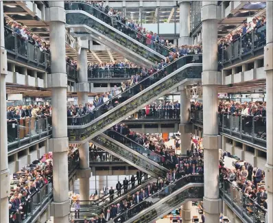  ??  ?? Poppies fall through the atrium of the Lloyd’s building during the Lloyd’s of London Armistice commemorat­ion service yesterday, watched by hundreds of staff of the insurance market, the world’s leading provider.