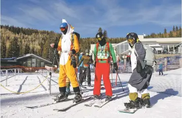  ?? JANE PHILLIPS/FOR THE NEW MEXICAN ?? From left, Russell Benson, Rob Payment and Michaela Beggins spend Christmas Day at Ski Santa Fe. Because of the pandemic, the resort is taking in less than half the revenue it normally would. Officials hope a winter storm forecast for Monday and Tuesday will bring enough snow to open the resort’s two highest chairlifts.