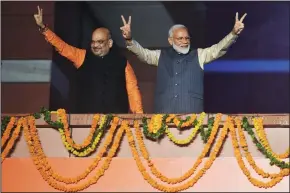  ?? PRAKASH SINGH/AFP/GETTY IMAGES ?? India Prime Minister Narendra Modi, right, and Bharatiya Janta Party president Amit Shah flash the victory sign as they celebrate the victory in India’s general election at the party headquarte­rs in New Delhi on Thursday.