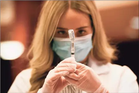  ?? Jessica Hill / Associated Press ?? A pharmacist readies a syringe of a COVID-19 vaccine from Johnson & Johnson and Janssen Pharmaceut­icals on Wednesday at Hartford Hospital.