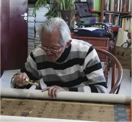  ??  ?? The author studying the calligraph­y scroll