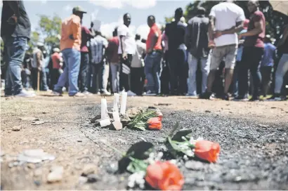  ?? Picture: Jacques Nelles ?? ANGRY CROWD. Candles and flowers near the site where Siyabonga Ngcobo’s burnt body was found during a protest march by Taxify and Uber drivers and TUT students yesterday.