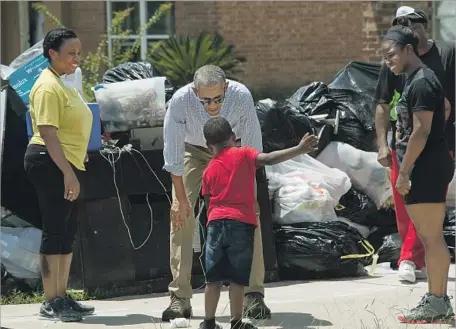  ?? Nicholas Kamm AFP/Getty Images ?? PRESIDENT OBAMA visits with a young resident of Baton Rouge, La. Obama commended the response of the Federal Emergency Management Agency, and the White House noted that $127 million has already been dispersed for rental assistance and insurance payments.