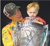  ?? Jared C. Tilton Getty Images ?? JOEY LOGANO celebrates with his son, Hudson, and the trophy after winning the Ford EcoBoost 400.